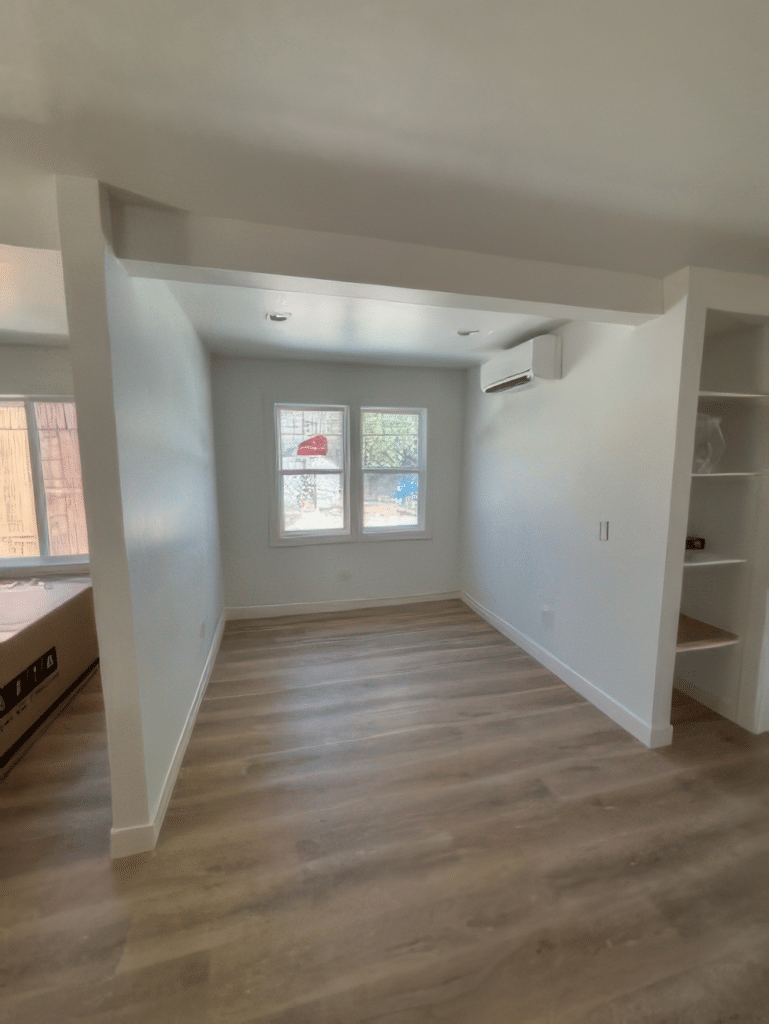 Professional Interior Painting Services for a Fresh Look A newly painted interior room with crisp white walls, light wood flooring, and a window, showcasing professional residential painting services.