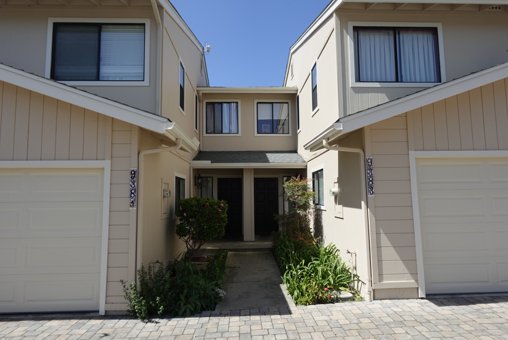 Multi Unit Residential and Townhouse Exterior Painting Freshly painted beige multi unit residential buildings with white trim and attached garages.