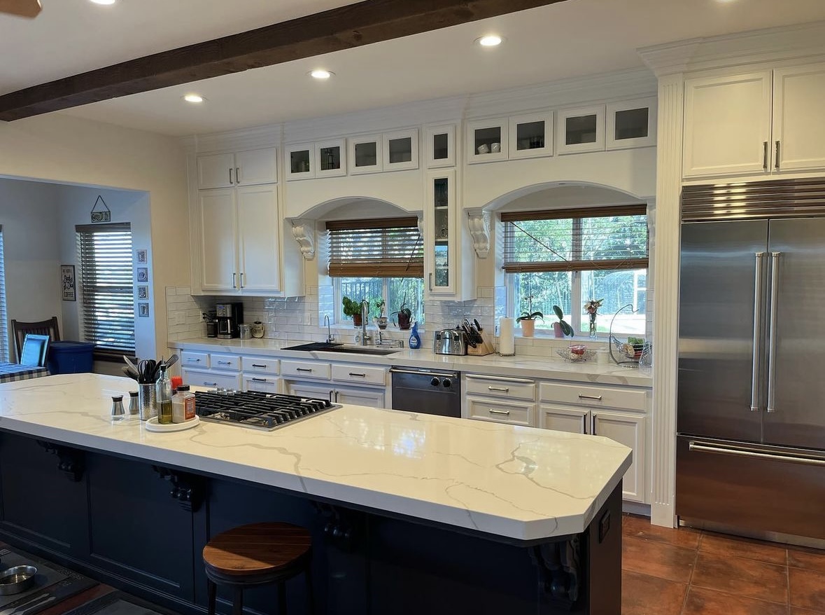 Stunning Kitchen Cabinet Painting with White Uppers and Dark Island A beautifully painted kitchen featuring crisp white upper cabinets and a contrasting dark blue island.