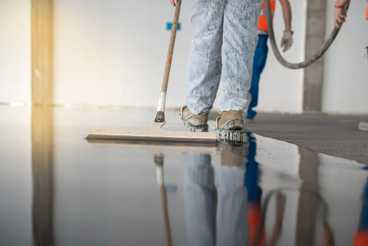 Worker applying epoxy floor coating to commercial garage floor Epoxy floor coating application