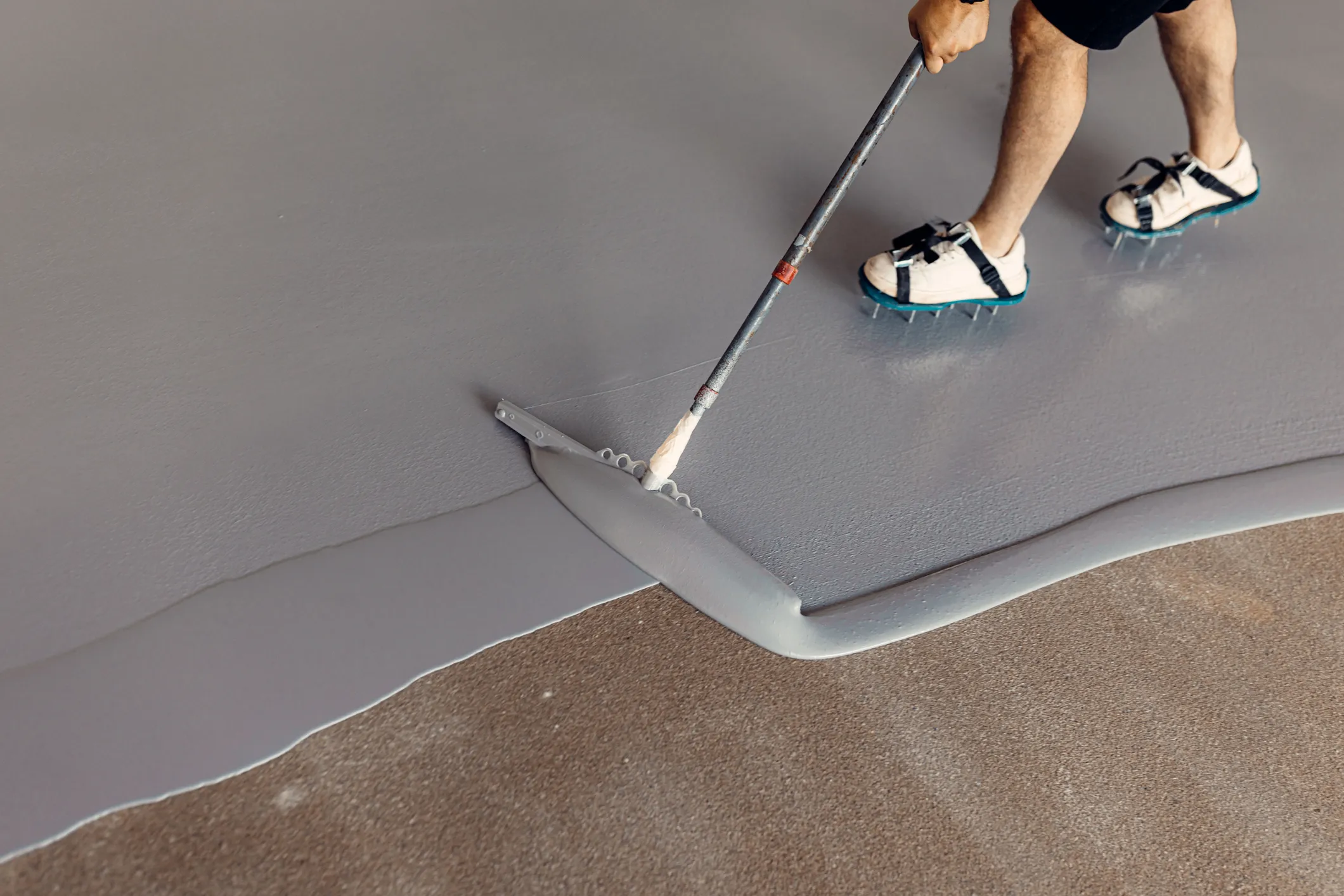 Worker applying epoxy floor roller finish coat Epoxy floor roller finish coat