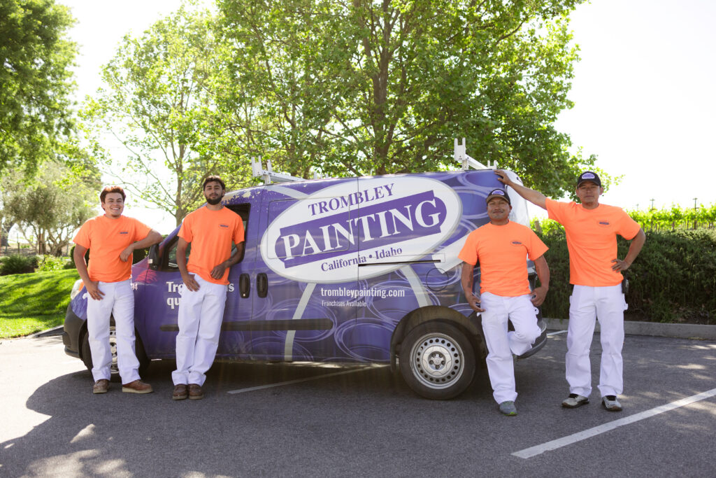 Trombley Painting Crew Ready for Professional Painting Services Trombley Painting crew of four professional painters stands by their branded van, ready for painting projects.